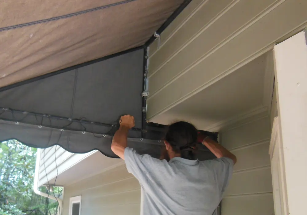 Retying the canvas to the awning frame at a home in Roswell.